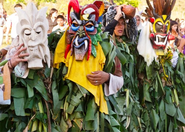 Boruca diablitos camouflaged with banana leaves and masks
