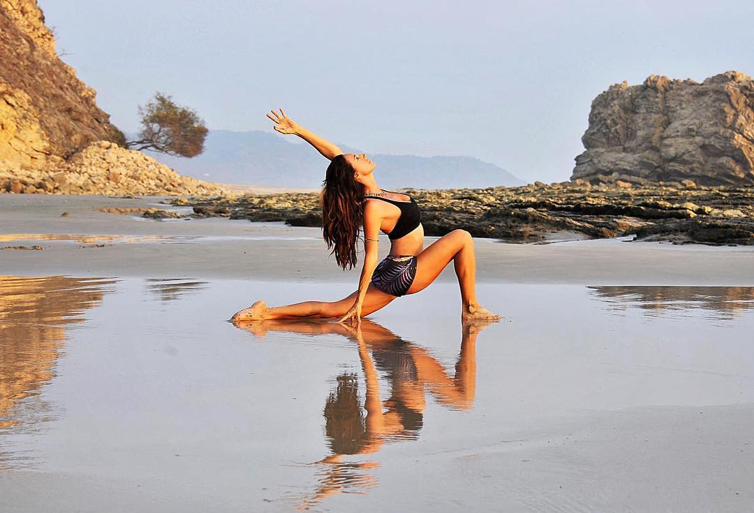 Nancy Goodfellow yoga lunge on Santa Teresa beach, photo credit nancygoodfellow108.